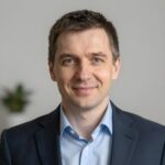 Портрет уверенного российского бизнесмена с дружелюбным взглядом на размытом нейтральном фоне студии